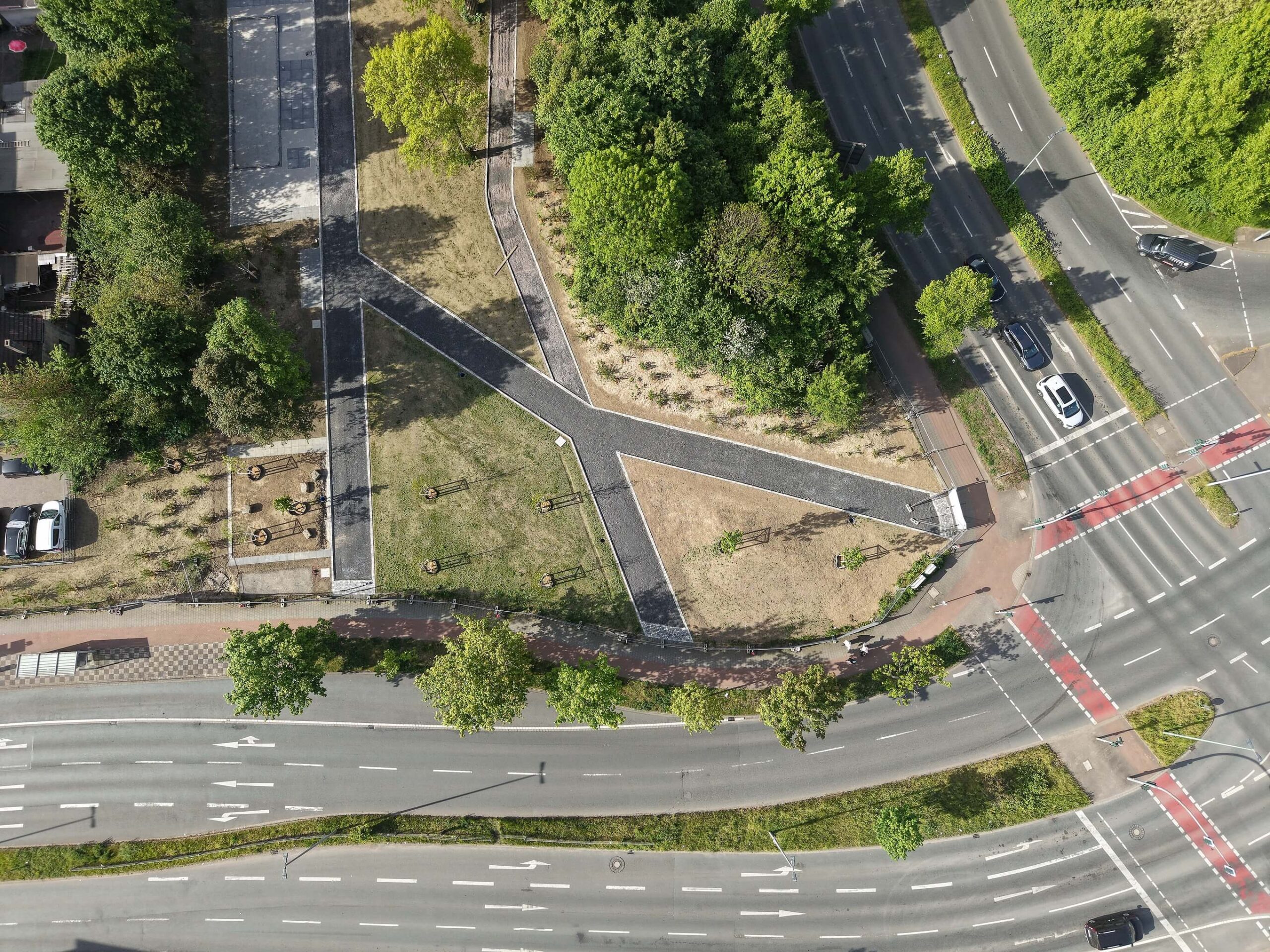 Blick von oben, auf die Bauarbeiten am Grünen Ring. Im Grünen Ring Süd sind Erdarbeiten und die Einfassung des künftigen Quartiersspielplatzes zu sehen. Erste Flächen sind bereits begrünt. Im Grünen Ring Mitte entstehen die ersten gepflasterten Wegeeinfassungen.